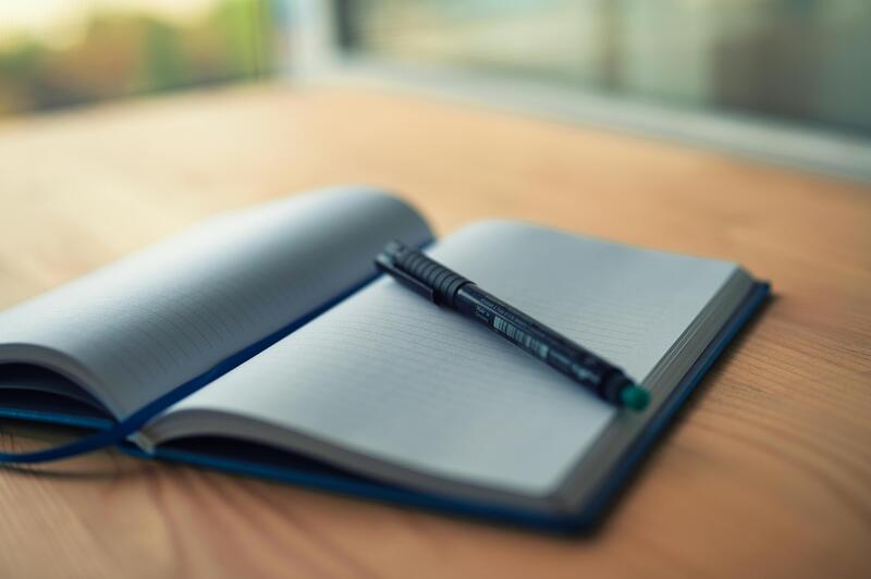 A notebook and pen on a desk for keeping records
