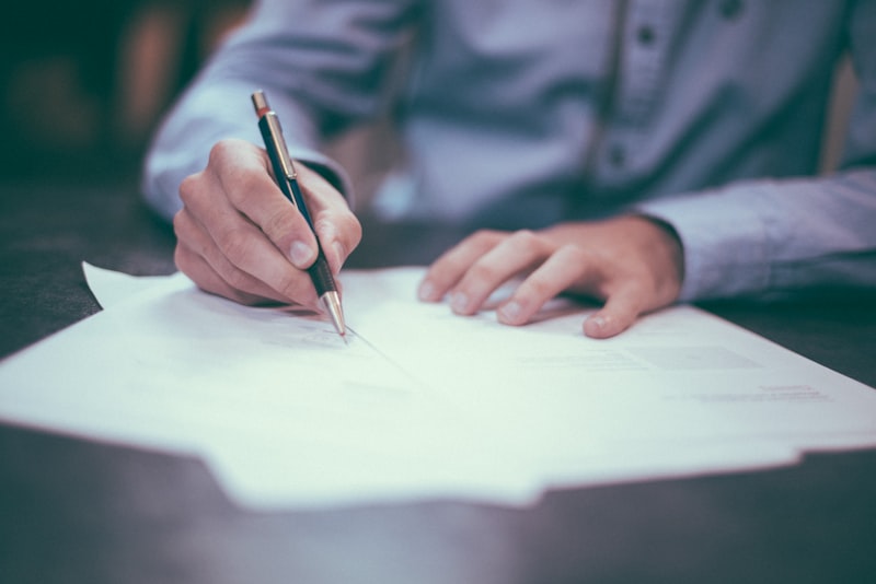 Person working at a desk with paperwork and laptop